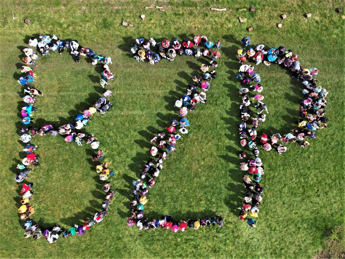 An aerial shot of the letters 'BZP' spelled out on a field made up of people standing to form the letters.